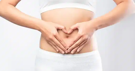 person forming heart with hands over stomach