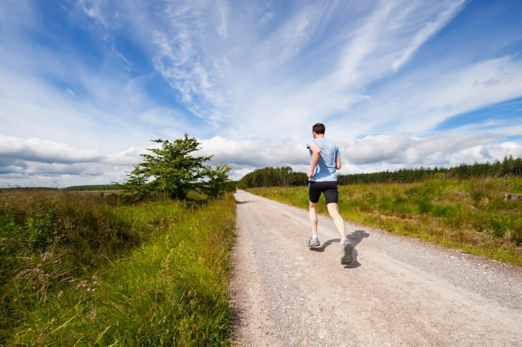 man running on a gravel road